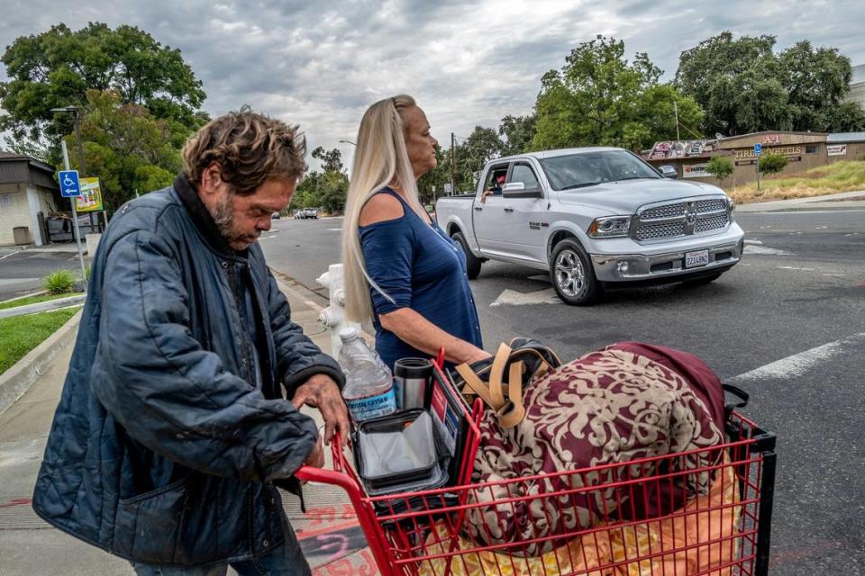 Linda Privatte guides her brother Mark Rippee, who is blind and mentally ill, across an intersection in Vacaville on Aug. 1. “He has delusions that won’t allow him to leave this particular area. It’s all that he remembers before he went blind,” said Privatte.