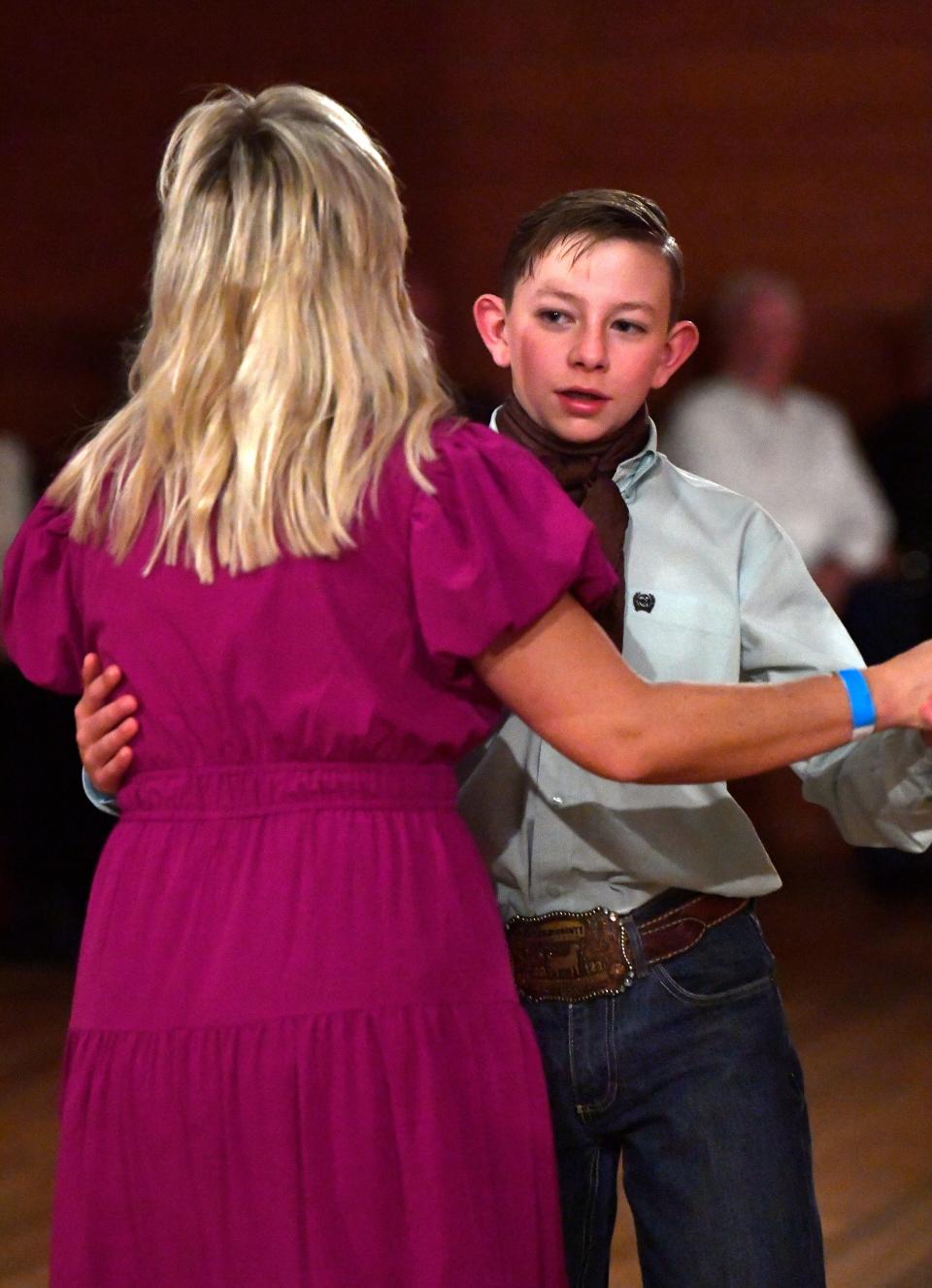 Hagen Hudson, 13, dances with his mother, Lindsay, during the Texas Cowboys’ Christmas Ball. The Hudson family traveled from Pampa to partake in the annual holiday tradition.