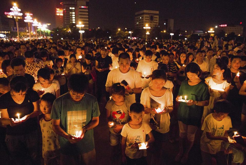 Residents gather as they attend a candlelight vigil for victims of a factory explosion, in Kunshan, Jiangsu province