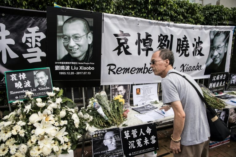 A man signs a condolence book at a makeshift memorial for the late Chinese Nobel laureate Liu Xiaobo, outside the Chinese Liaison Office in Hong Kong on July 15, 2017