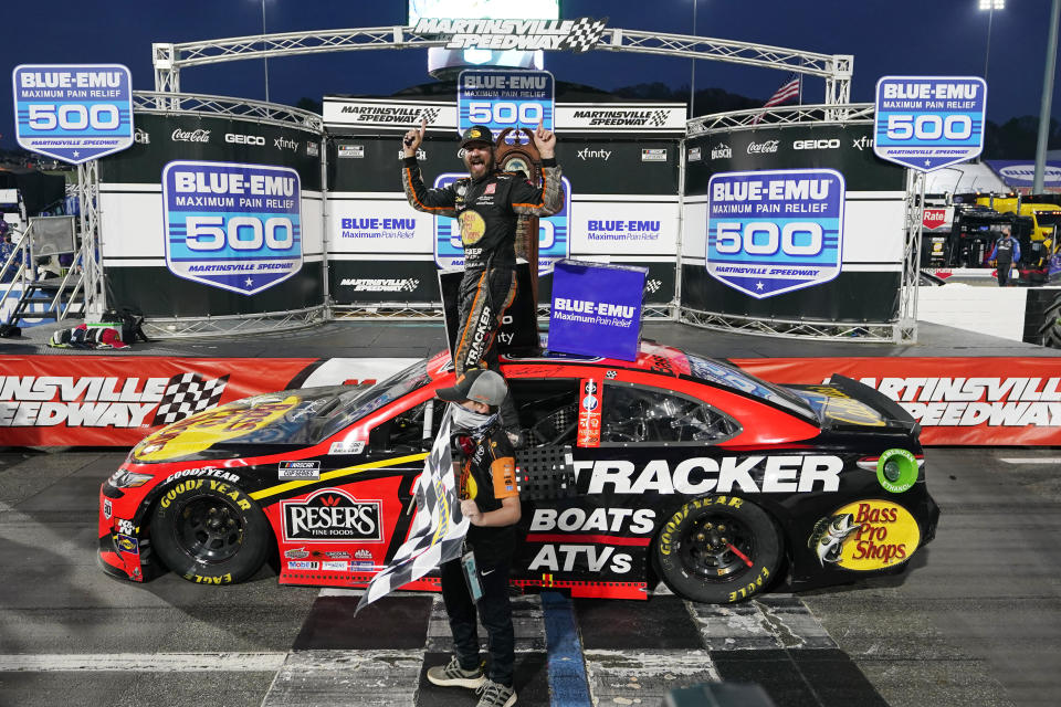 Martin Truex Jr., top, celebrates after winning a NASCAR Cup Series auto race at Martinsville Speedway in Martinsville, Va., Sunday, April 11, 2021. (AP Photo/Steve Helber)