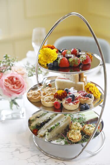 A three-tiered tower of finger sandwiches and other treats graces a table at the tea room of the Huntington in San Marino.