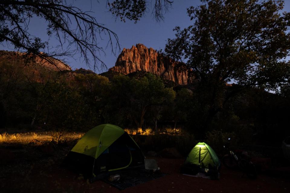 Tents glow as dusk settles in on Watchman Campground during gathering of atheists and friends