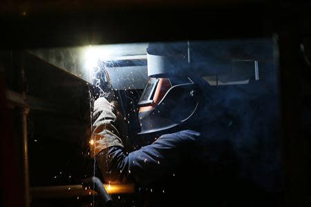 A welder works on a section of a Royal Navy aircraft carrier at BAE Systems Govan yard in Glasgow, Scotland January 16, 2014. REUTERS/Stefan Wermuth