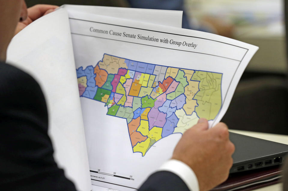 FILE - In this July 26, 2017, file photo, a lawmaker studies a district map during a joint select committee meeting on redistricting in Raleigh, N.C. Republican wins in state legislatures in 2010 put them in a commanding position to draw legislative and congressional maps the following year that essentially cemented their political power for a decade. (AP Photo/Gerry Broome, File)