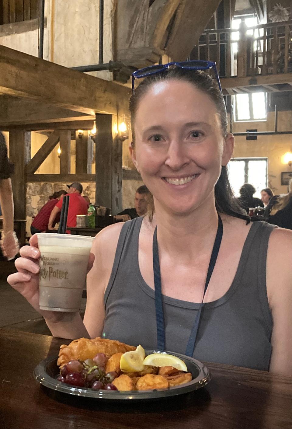 lisa galek smiling and holding food and drinks at Universal