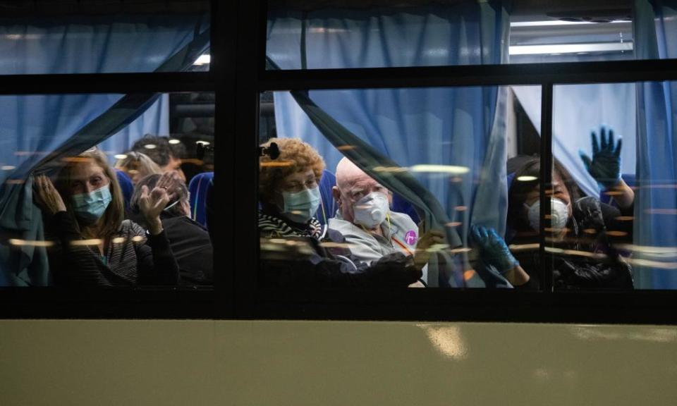 US citizens wave from a bus as they leave cruise ship to be repatriated