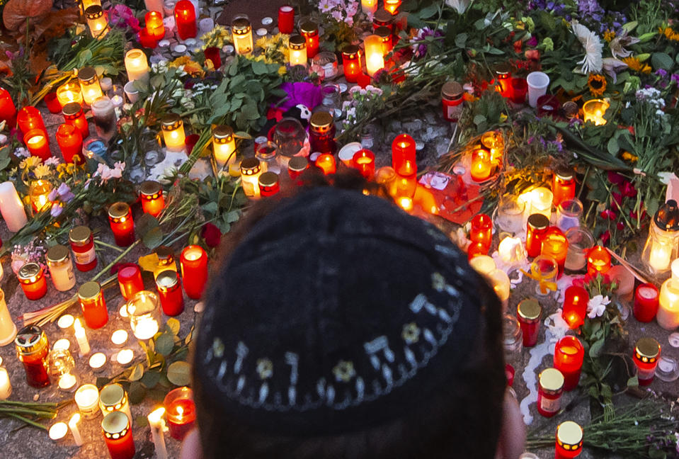 A man mourns as he taking part in a human chain around the Jewish synagogue during the Sabbath celebrations in Halle, Germany, Friday, Oct. 11, 2019. A heavily armed assailant ranting about Jews tried to force his way into a synagogue in Germany on Yom Kippur, Judaism's holiest day, then shot two people to death nearby in an attack Wednesday that was livestreamed on a popular gaming site. (AP Photo/Jens Meyer)