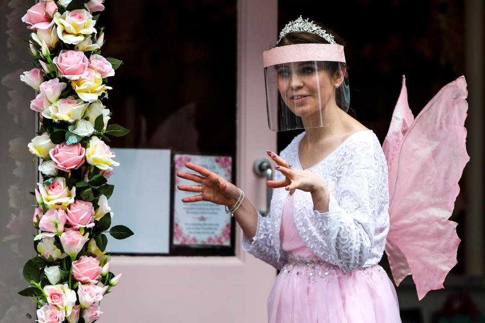 <p>A waitress dressed as a fairy serves a customer outside the Petite Fairytale Boutique in Worthing town centre, Sussex, as England takes another step back towards normality with the further easing of lockdown restrictions. Picture date: Monday April 12, 2021.</p>
