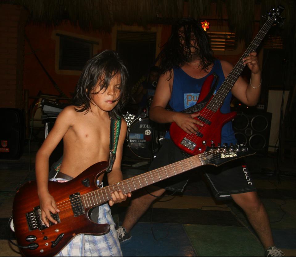 This Jan. 6, 2013 photo shows child guitar prodigy Cainn Cruz, left, performing at the Posada Mexico restaurant in Zipolite, Mexico. The ocean-front restaurant offers a variety of live entertainment. A sleepy town with one main street and no ATMs, Zipolite is one many tiny coastal pueblos that dot the Pacific in Mexico's Southern state of Oaxaca. (AP Photo/Jody Kurash)