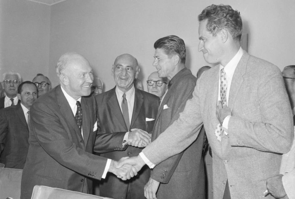 Charlton Heston (right) shakes hands with Charles S. Boren, vice president of the Association of Motion Picture Producers, as the Screen Actors Guild ended its strike against major picture studios in 1960.