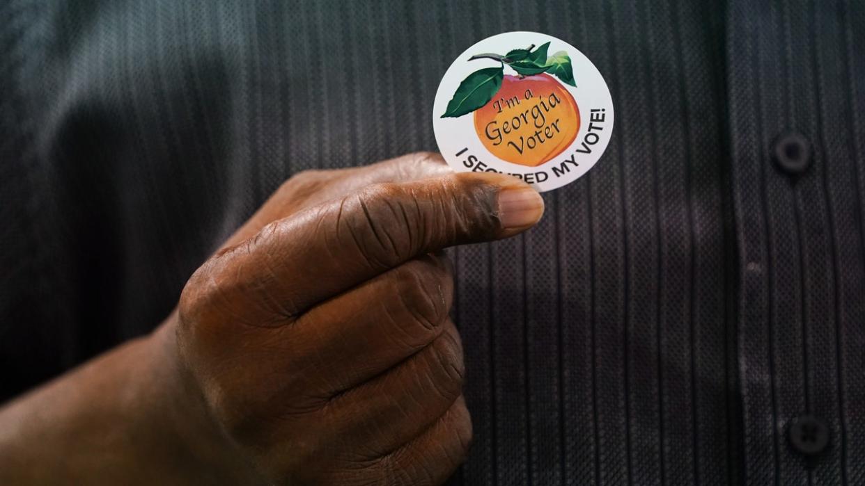 <div>A resident holds an "I'm A Georgia Voter" sticker at an early voting polling location for the 2020 Presidential election in Atlanta, on Monday, Oct. 12, 2020. (Photographer: Elijah Nouvelage/Bloomberg via Getty Images)</div>
