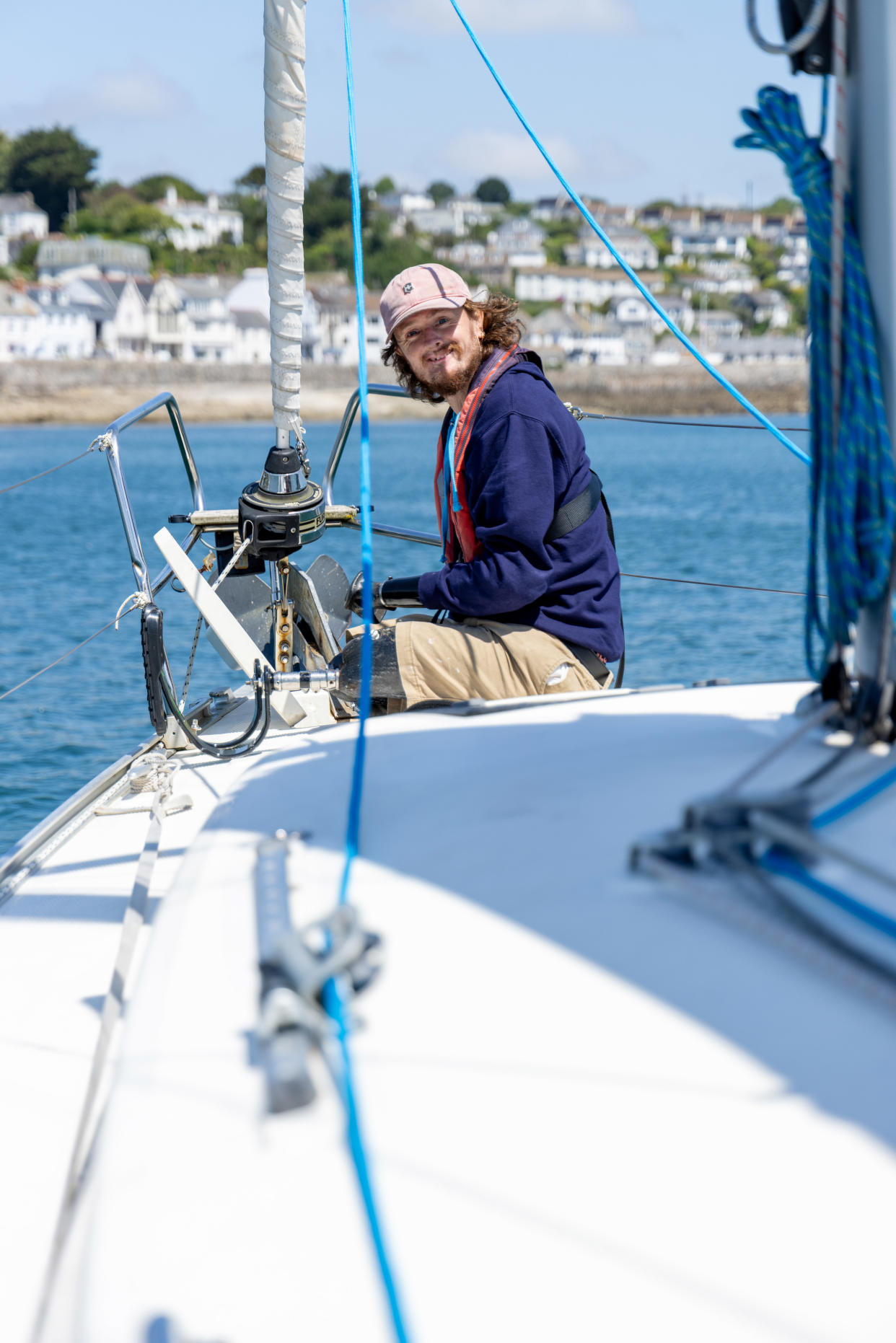 Craig Wood sitting on his sailing boat and smiling at the camera 