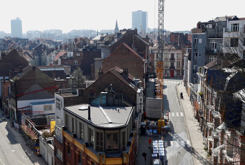 A man pulls a shopping trolley in a deserted street in Brussels