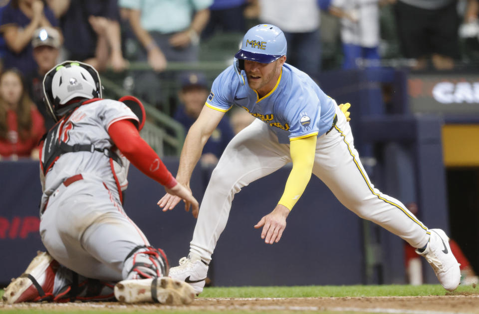 Cincinnati Reds' Tyler Stephenson, left, prepares to tag out Milwaukee Brewers' Jake Bauers during the ninth inning of a baseball game Friday, June 14, 2024, in Milwaukee. (AP Photo/Jeffrey Phelps)