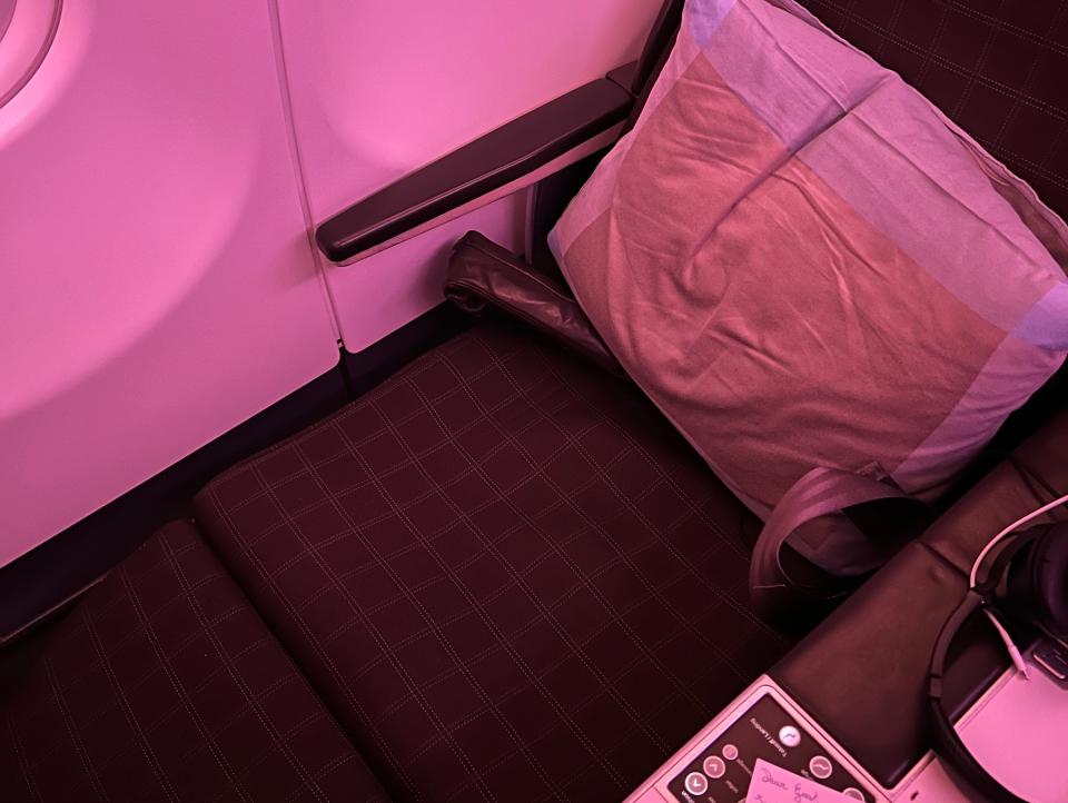 my business-class seat in lounge position with pink lighting