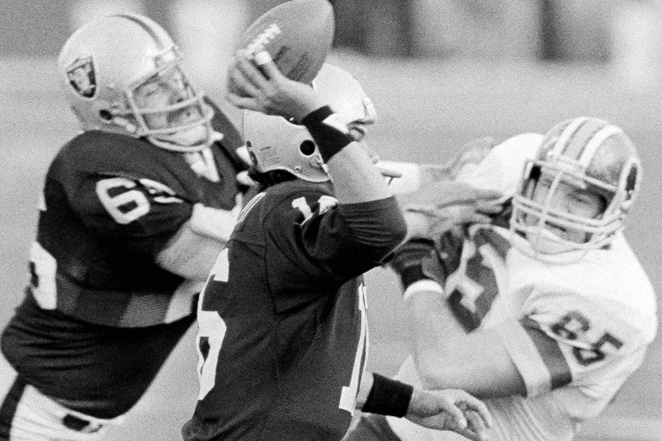 FILE - Los Angeles Raiders quarterback Jim Plunkett prepares to pass under pressure as Washington Redskins' Dave Butz, right, closes in during first quarter action, Sunday, Jan. 22, 1984, during Super Bowl XVIII in Tampa, Fla. Holding off Butz is Raiders Steve Sylvester, left, All-Pro defensive lineman and two-time Washington Super Bowl champion Dave Butz has died. He was 72. A spokesman for the Washington Commanders confirmed that Butz’s family informed the team about his death Friday. It was not immediately known where Butz died or the cause of his death. (AP Photo/File)