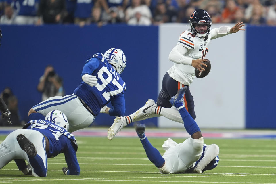 Chicago Bears quarterback Caleb Williams (18) scrambles under pressure from Indianapolis Colts defensive end Dayo Odeyingbo (54), defensive end Laiatu Latu (97) and linebacker Zaire Franklin (44) during the first half of an NFL football game Sunday, Sept. 22, 2024, in Indianapolis. (AP Photo/Michael Conroy)