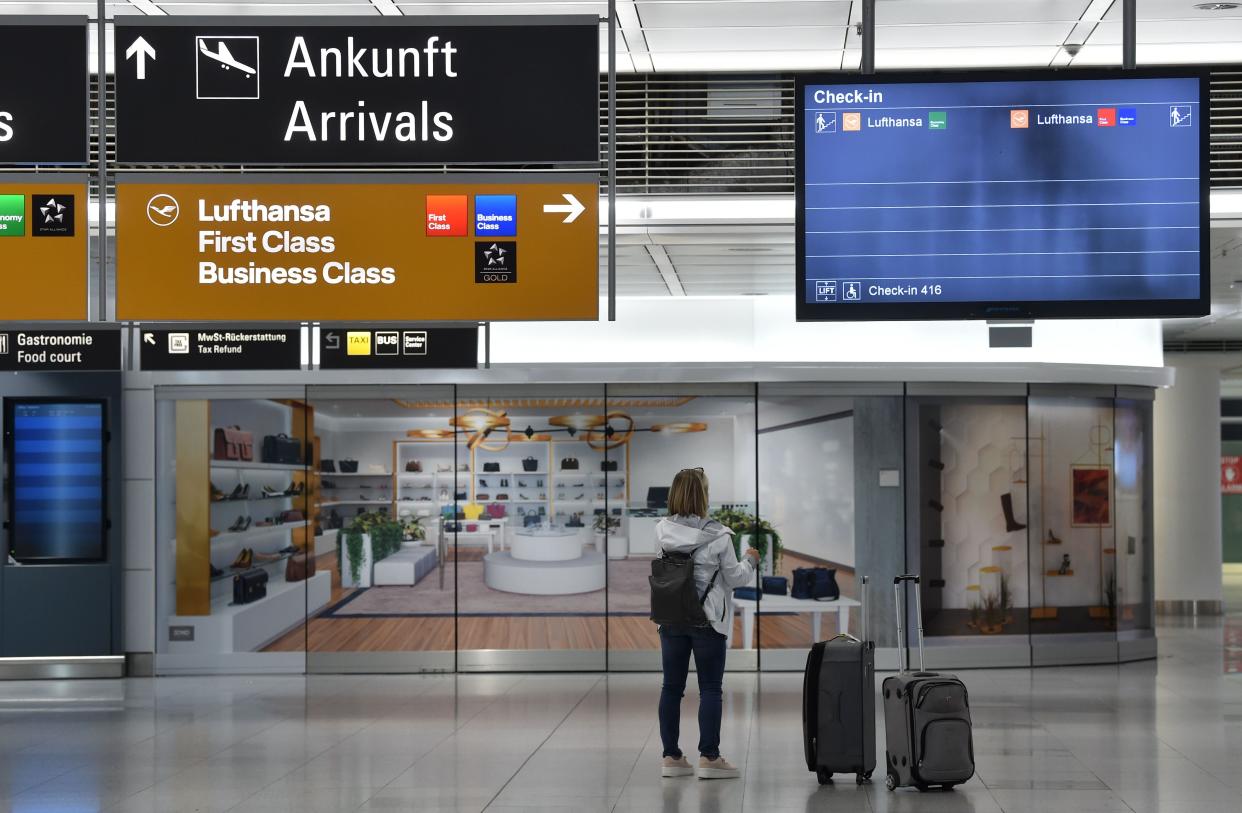 A passenger stand in front of a check-in screen at the “Franz-Josef-Strauss” airport in Munich. Germany has warned it will have to close its borders to prevent the new variant (AFP via Getty Images)