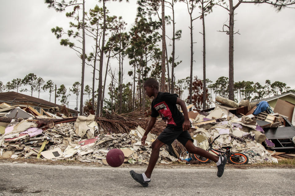 A boy dribbles a ball through debris caused by Hurricane Dorian in Freeport, Grand Bahama Sept. 21, 2019. (Photo: Maria Alejandra Cardona for HuffPost)