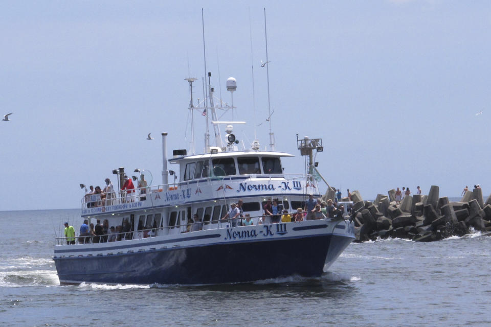 A fishing boat enters the Manasquan Inlet in Manasquan, N.J. on July 10, 2015 after taking customers on a fishing trip in the ocean. A report issued March 29, 2023 by two federal marine science agencies and the commercial fishing industry highlighted several potential negative aspects of offshore wind energy development on the fishing industry and called for additional research. (AP Photo/Wayne Parry)