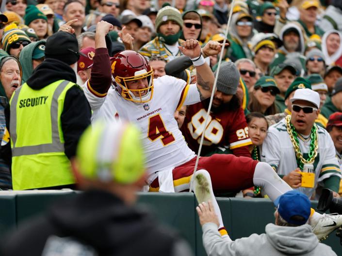 Taylor Heinicke jumps into the crowd during a game against the Green Bay Packers.