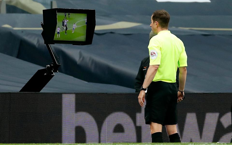 Referee Peter Bankes checks the VAR pitch side monitor before giving a penalty for a hand ball against Tottenham Hotspur's Eric Dier  - PA