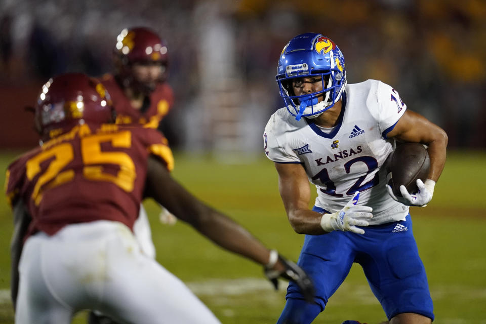 Kansas wide receiver Torry Locklin (12) runs from Iowa State defensive back T.J. Tampa (25) after catching a pass during the first half of an NCAA college football game, Saturday, Oct. 2, 2021, in Ames, Iowa. (AP Photo/Charlie Neibergall)