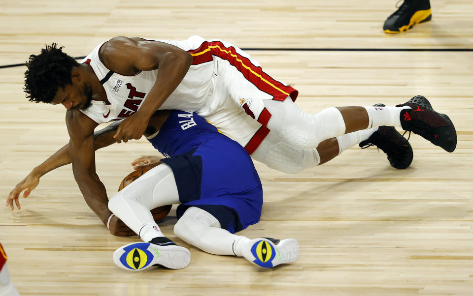 Denver Nuggets' Monte Morris, bottom, and Miami Heat's Jimmy Butler scramble for the ball during an NBA basketball game, Saturday, Aug. 1, 2020, in Lake Buena Vista, Fla. (Kevin C. Cox/Pool Photo via AP)