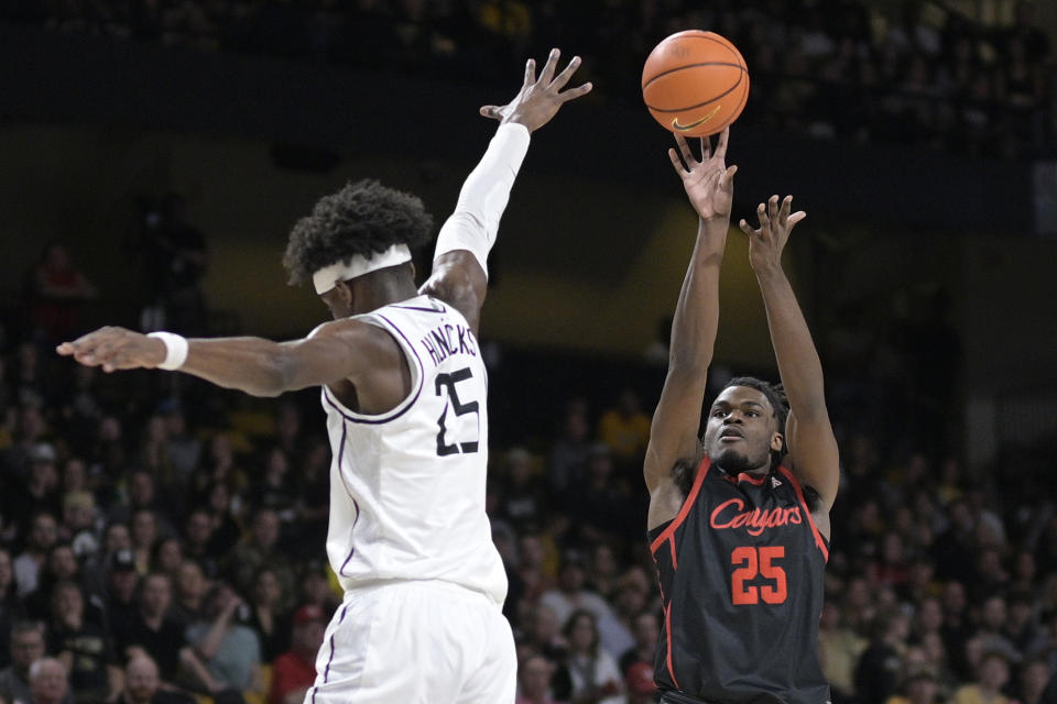 Houston forward Jarace Walker (25) shoots a 3-pointer in front of Central Florida forward Taylor Hendricks (25) during the first half of an NCAA college basketball game, Wednesday, Jan. 25, 2023, in Orlando, Fla. (AP Photo/Phelan M. Ebenhack)