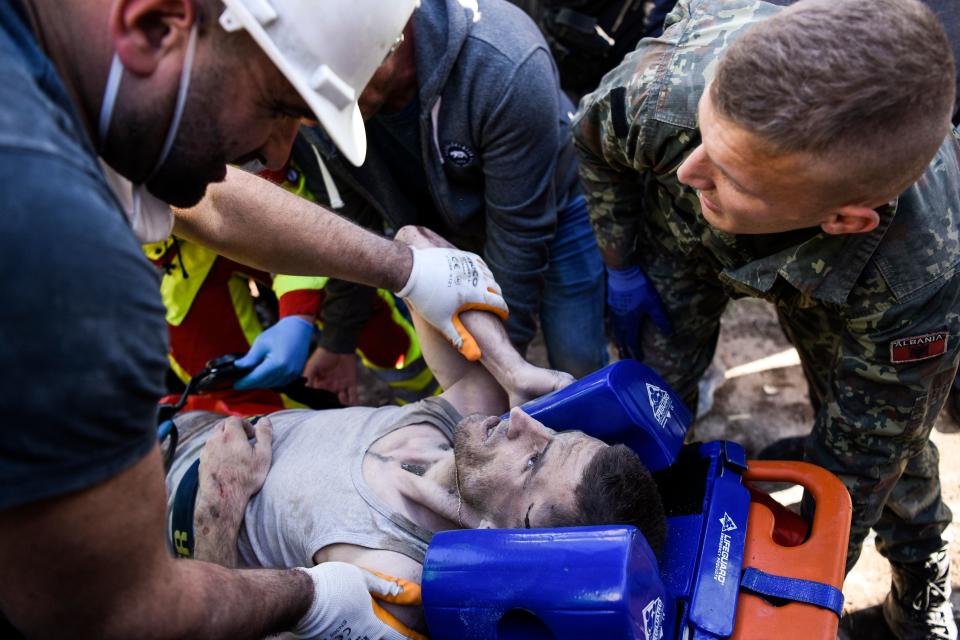 Soldiers and rescue workers carry an injured man found in debris of a collapsed building in  Thumane, northwest of capital Tirana, after an earthquake hit Albania, on November 26, 2019. (Photo: Armend NimaniI/AFP via Getty Images)