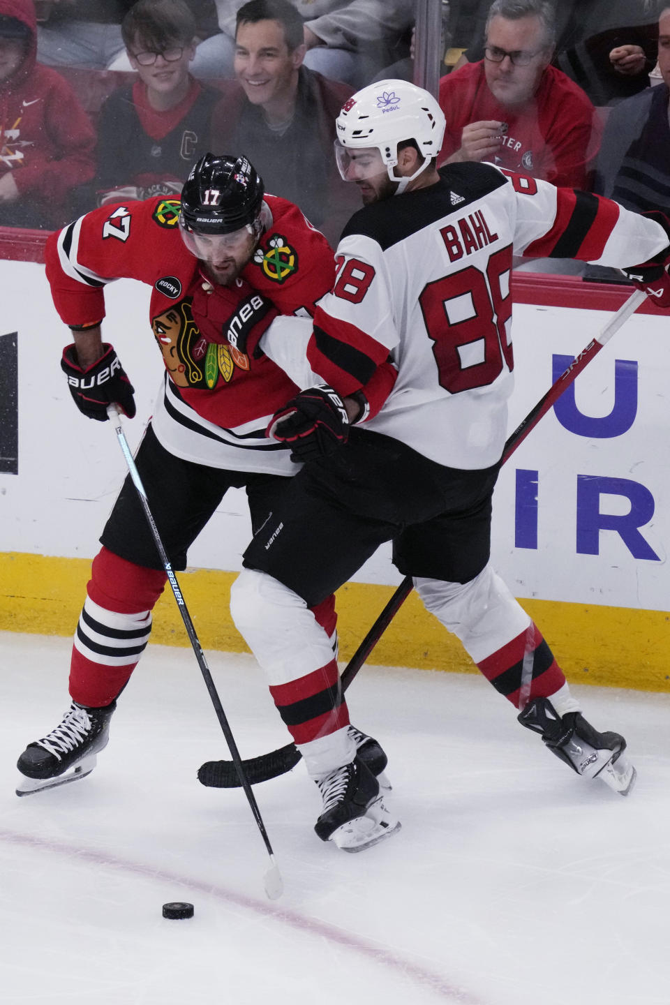 Chicago Blackhawks left wing Nick Foligno, left, and New Jersey Devils defenseman Kevin Bahl, right, battle for the puck during the second period of an NHL hockey game in Chicago, Sunday, Nov. 5, 2023. (AP Photo/Nam Y. Huh)