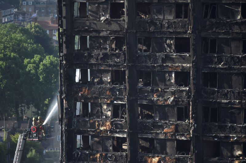 FILE PHOTO: Firefighters spray water onto the Grenfell Tower block which was destroyed in a disastrous fire, in north Kensington, West London