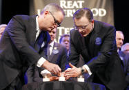 Rev. Adam Hamilton, left, and Fr. Stephen Cook, right, light candles victims of this weeks shootings during an Interfaith Service of Unity and Hope at the Jewish Community Center in Overland Park, Kan., Thursday, April 17, 2014. Frazier Glenn Cross, 73, is charged with the killings Sunday of Dr. William Lewis Corporon and his grandson, Reat Griffin Underwood, outside the Jewish Community Center of Greater Kansas City. Cross is also accused of killing Terri LaManno at a nearby Jewish retirement complex. (AP Photo/Orlin Wagner)