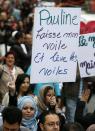 A demonstrator carries a sign that reads "Pauline (Marois) leave my veil and lift your curtains" during a protest against Quebec's proposed Charter of Values in Montreal, September 14, 2013. Thousands took to the streets to denounce the province's proposed bill to ban the wearing of any overt religious garb by government paid employees. REUTERS/Christinne Muschi(CANADA - Tags: POLITICS CIVIL UNREST RELIGION)