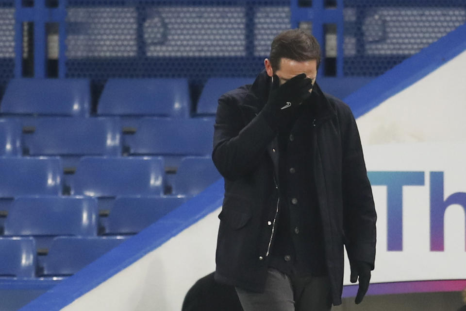 Frank Lampard, técnico del Chelsea, se cubre el rostro durante el encuentro que su equipo empató frente al Aston Villa, el lunes 28 de diciembre de 2020 (Catherine Ivill/Pool via AP)