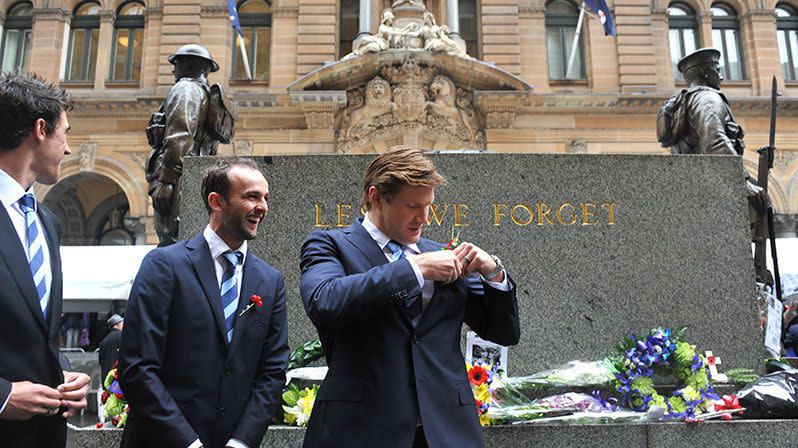 Australian cricket players Shane Watson, Nathan Lyon and Mitchell Starc prepare to pose for a photograph in front of the centoph in Martin Place following a Remembrance Day service in Sydney. Photo: AAP