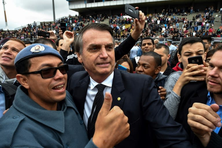 Brazilian presidential favorite Jair Bolsonaro, pictured posing with a military man in August 2018, is a former army captain