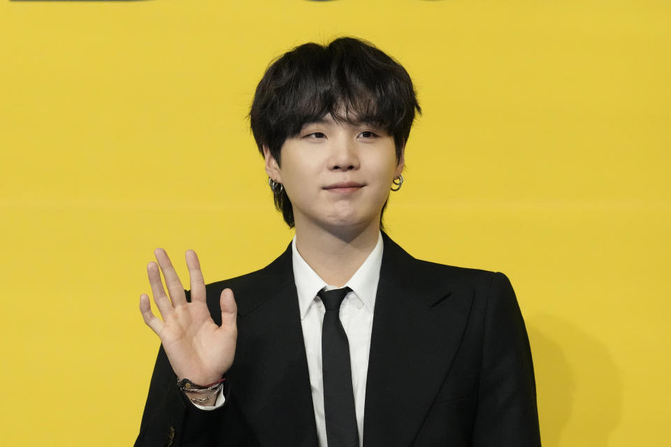 SUGA, a member of South Korean K-pop band BTS, poses for photographers ahead of a press conference to introduce their new single "Butter" in Seoul, South Korea, Friday, May 21, 2021. Three members of the K-pop superstar group BTS have been infected with the coronavirus. the Big Hit Entertainment agency says in a statement that RM and Jin were diagnosed with COVID-19 on Saturday evening. It earlier said another member, Suga, tested positive for the virus on Friday. (AP Photo/Lee Jin-man)