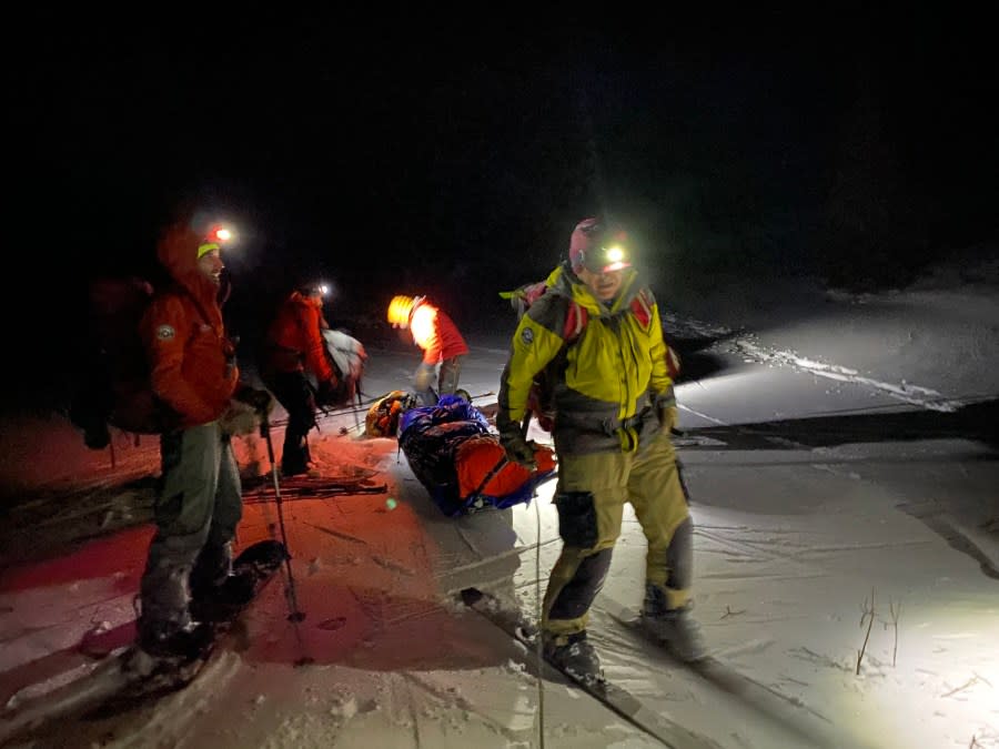 Crews from Alpine Rescue Team tend to an avalanche forecaster at night