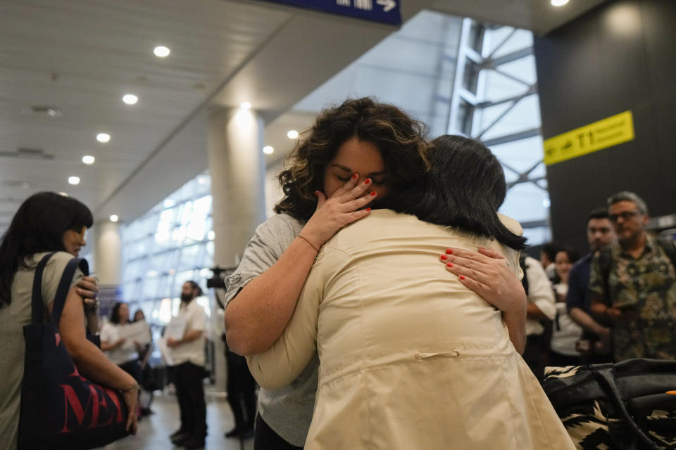 María Hastings, who lives in Tampa, FL, embraces for first time her biological mother upon her arrival to the airport in Santiago, Chile, Sunday, Feb. 18, 2024. Hasting trip was organized by Connecting Roots, an organization that helps reunite with their Chilean biological families children who were taken to be put up for adoption during the dictatorship of Gen. Augusto Pinochet. (AP Photo/Esteban Felix)