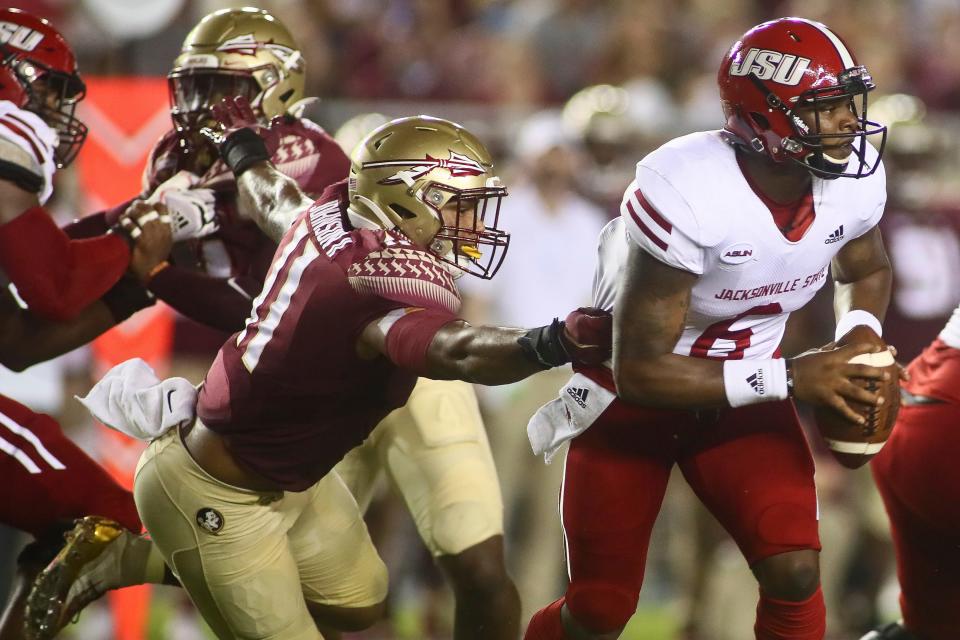 Florida State defensive end Jermaine Johnson II reaches for Jacksonville State quarterback Zerrick Cooper, right, last month during Jacksonville State’s surprising win.