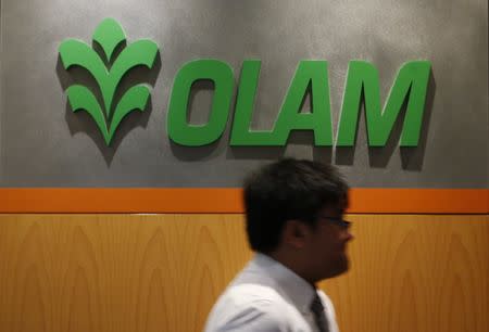 A man walks past a logo of Olam International Limited at its office in Singapore November 29, 2012. REUTERS/Edgar Su/Files