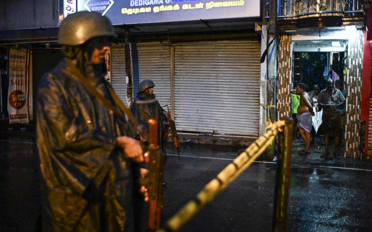 Sri Lankan soldiers stand guard under the rain at St. Anthony's Shrine in Colombo - AFP