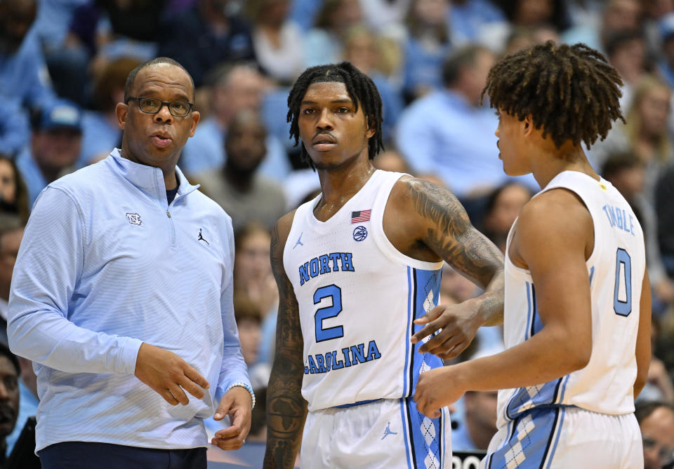 North Carolina coach Hubert Davis talks with Caleb Love (2) and Seth Trimble (0). The Tar Heels are off to a disappointing 5-2 start. (Photo by Grant Halverson/Getty Images)