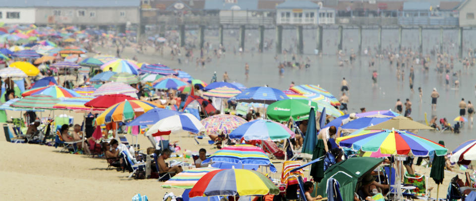 FILE - This July 12, 2011 file photo shows beach umbrellas with beach enthusiasts crowding the shores of Old Orchard Beach, Maine. The miles of white-sand beach in the oceanfront town of Old Orchard Beach will dispel any notion that Maine's coastline is all rough and rocky. The beach is a 20-minute drive from Portland and stretches for seven miles from Scarborough to Saco. When you're not on the beach itself, the town has carnival rides and amusements, gifts shops and plenty of restaurants and takeout spots with food like pizza, fried dough and cotton candy. (AP Photo/Pat Wellenbach, file)
