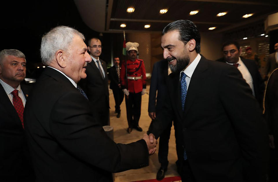 This photo provided by Iraqi Parliament Media Office, Iraq's Parliament Speaker Mohamed al-Halbusi, right, shakes hands with Newly elected Iraqi President Abdul Latif Rashid before the parliament session to approve the new government in Baghdad, Iraq, Thursday, Oct.27, 2022. (Iraqi Parliament Media Office via AP)