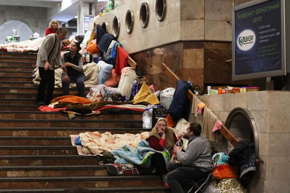 People sitting on a stairway in a subway station shelter