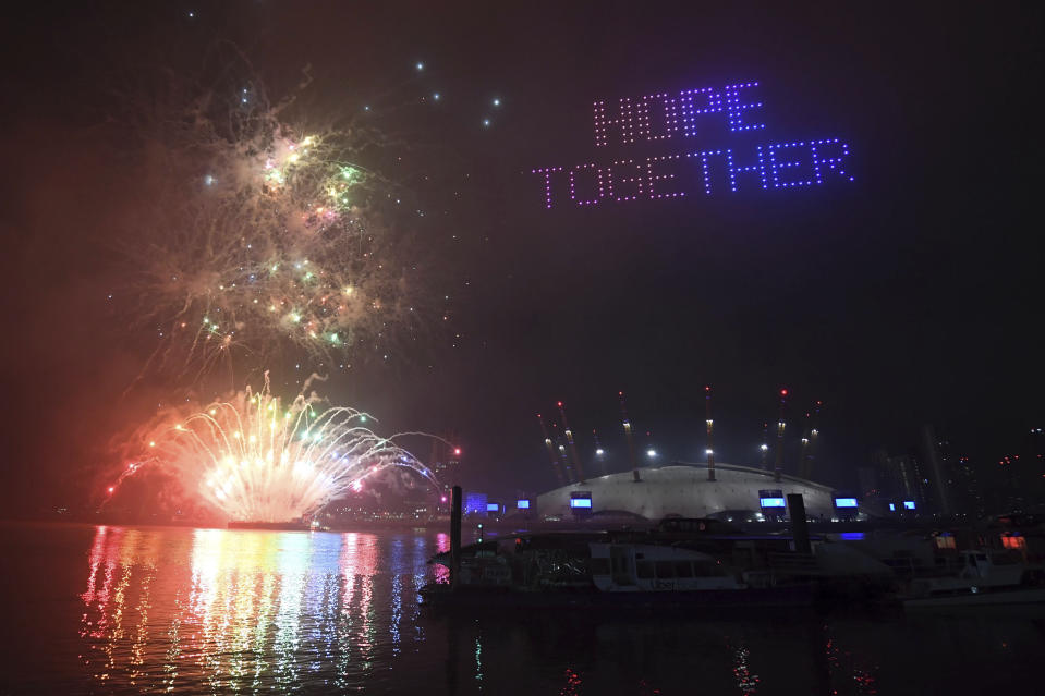 Fireworks and drones illuminate the night sky over London as they form a light display as London's normal New Year's Eve fireworks display was cancelled due to the coronavirus pandemic Thursday Dec. 31, 2020. (Victoria Jones/PA via AP)