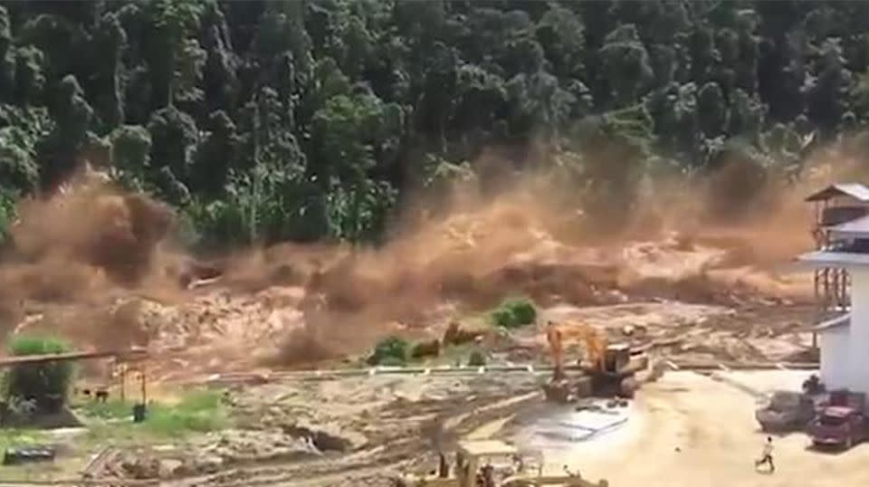 The burst reservoir sent muddy water flooding over a Laos construction site. Source: Facebook